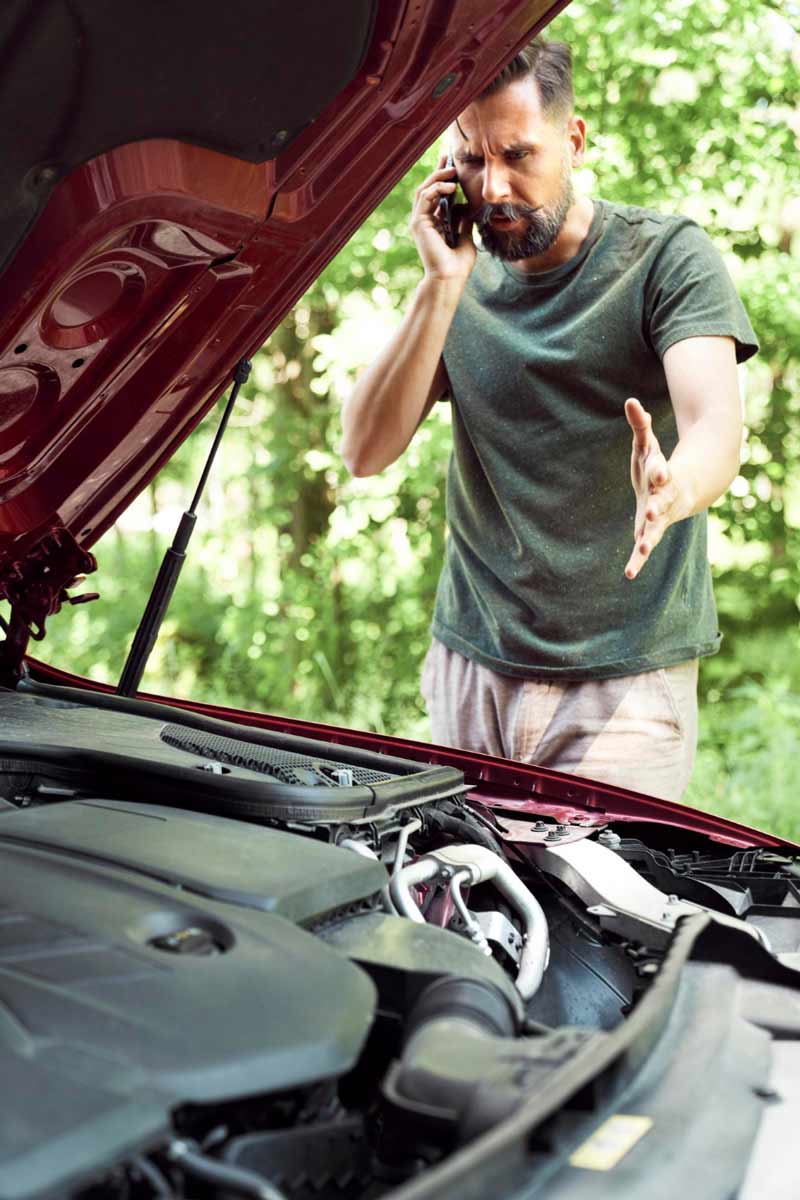 Junger Mann prüft Getriebeschaden bei Schrottauto Ankauf Ostholstein